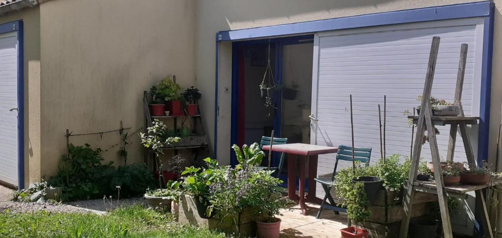 un garage avec une table et quelques plantes dans l'établissement grand studio de plein-pied quartier calme proche centre, à La Roche-sur-Yon