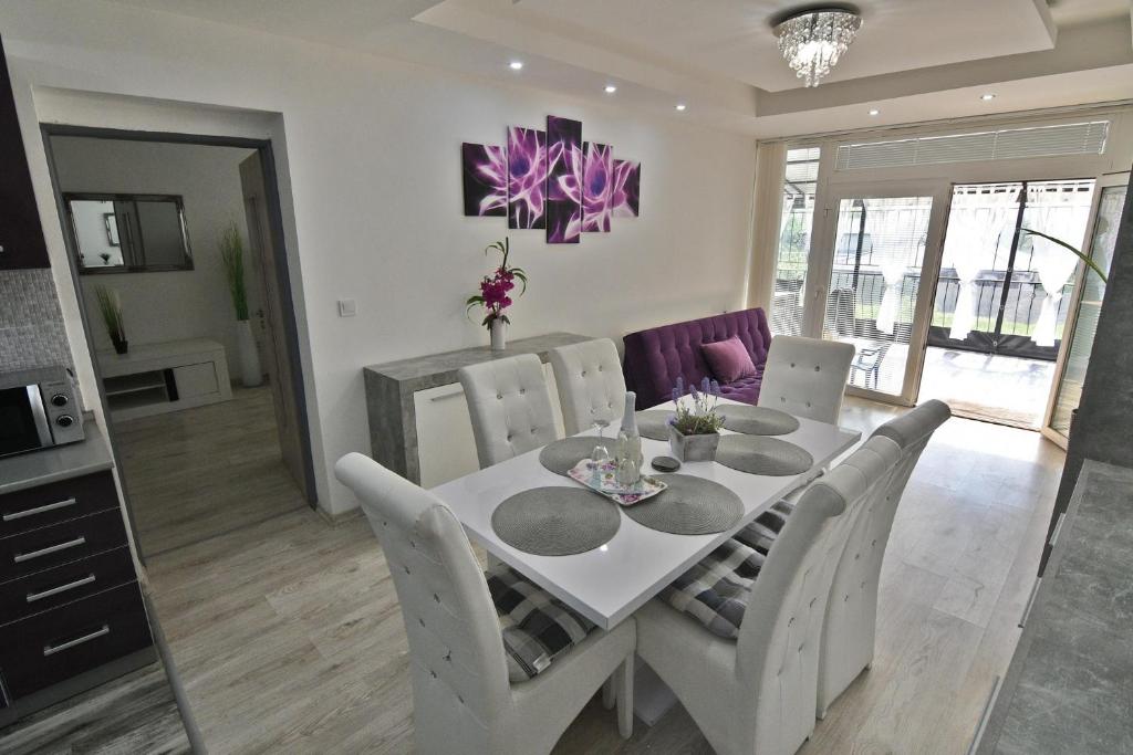 ein Esszimmer mit einem weißen Tisch und Stühlen in der Unterkunft Apartman Zemplinska Širava Timea in Kaluža