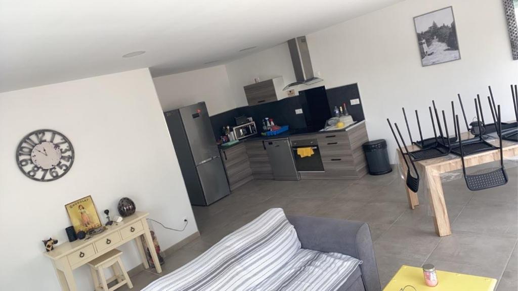 un salon avec une table et une cuisine dans l'établissement Le petit NiCe, à Caromb