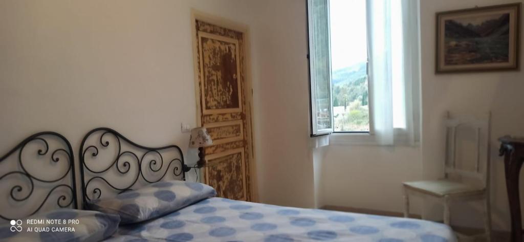 Schlafzimmer mit einem Bett und einem Fenster mit Aussicht in der Unterkunft CASA SUL TORRENTE in Rocchetta Nervina