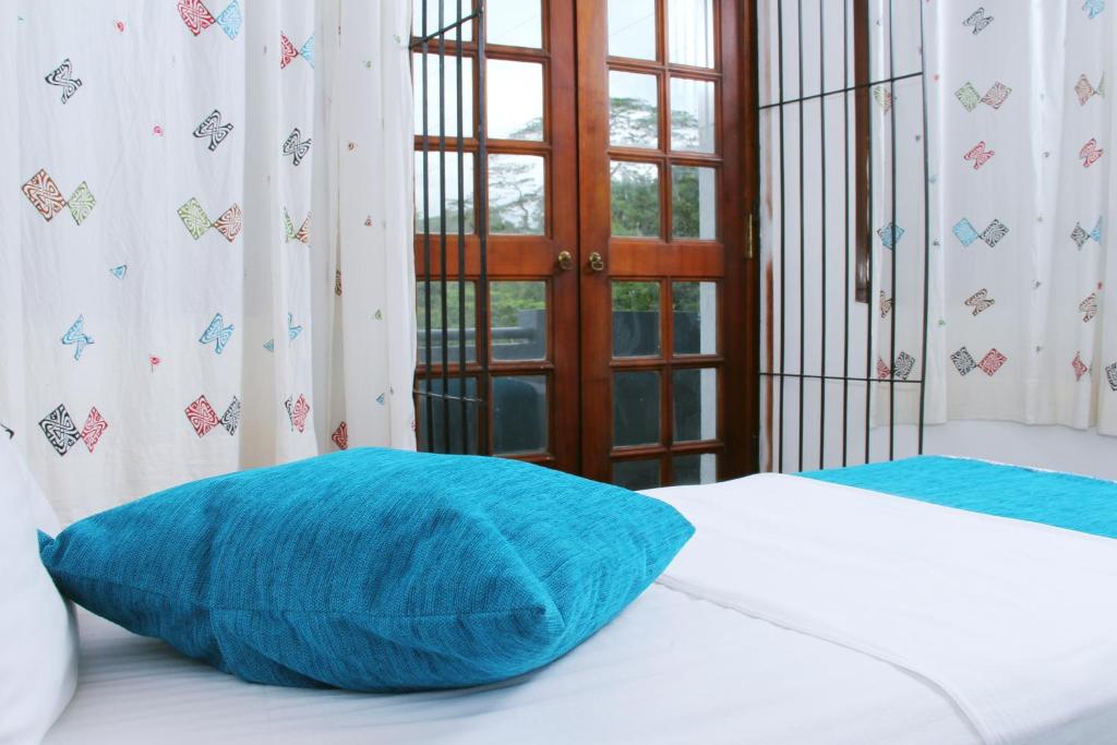 a blue pillow sitting on top of a bed at Bethel Rest Homestay in Kandy