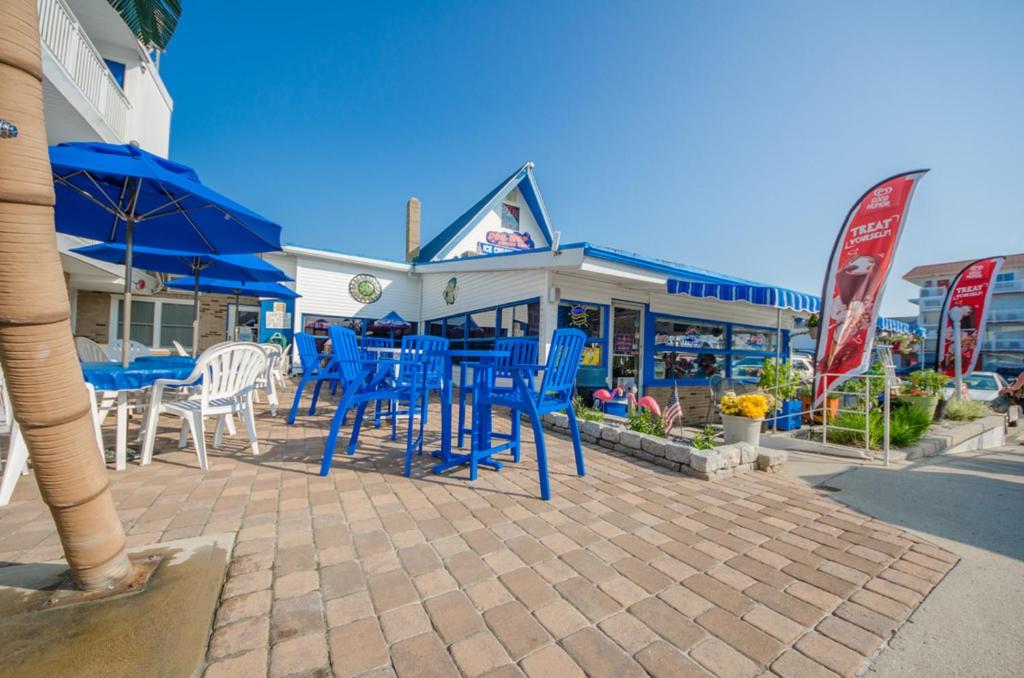a group of blue chairs and tables in front of a store at Tangiers Resort Motel in Wildwood Crest
