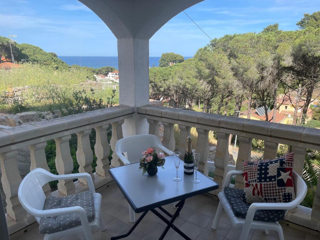 een tafel en stoelen op een balkon met uitzicht op de oceaan bij Casa Piedra Abajo in Pals