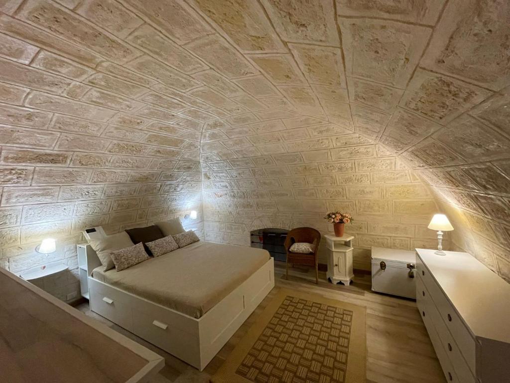 a bedroom with a bed and a stone wall at Casa della Luna in Bari