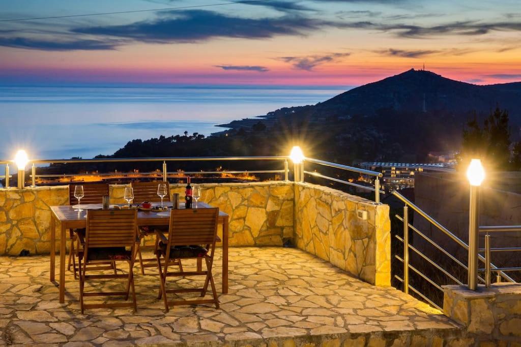 Doa - Apartment with Lovely Terrace & Sea View في مْليني: طاولة وكراسي على شرفة في الليل