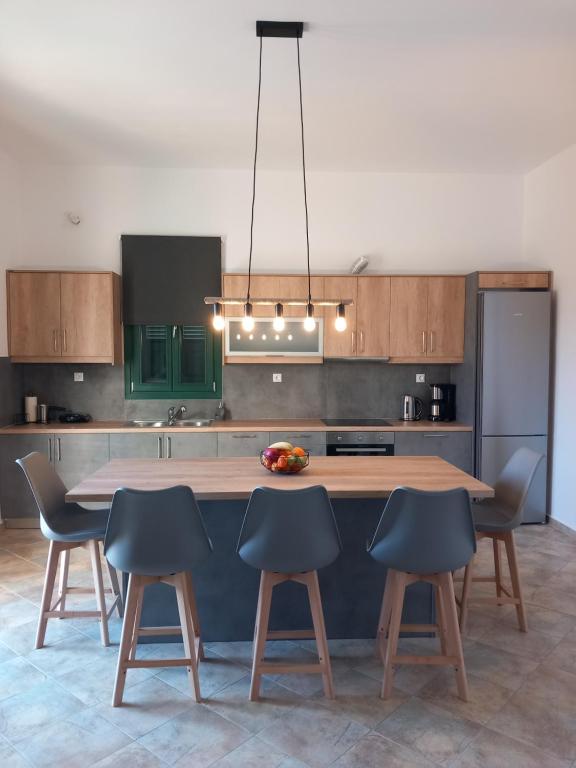 a kitchen with a wooden table and four chairs at Aurora Andros House in Korthi