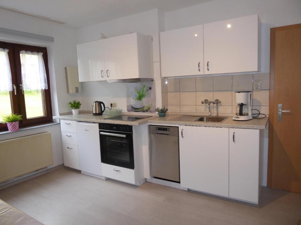 a kitchen with white cabinets and a sink at City-Apartment Lüdenscheid in Lüdenscheid