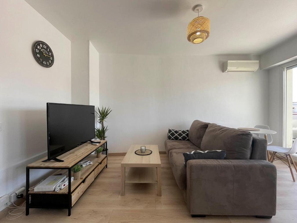 a living room with a couch and a tv at California Park - Wifi, AC, 4 pers in Nice
