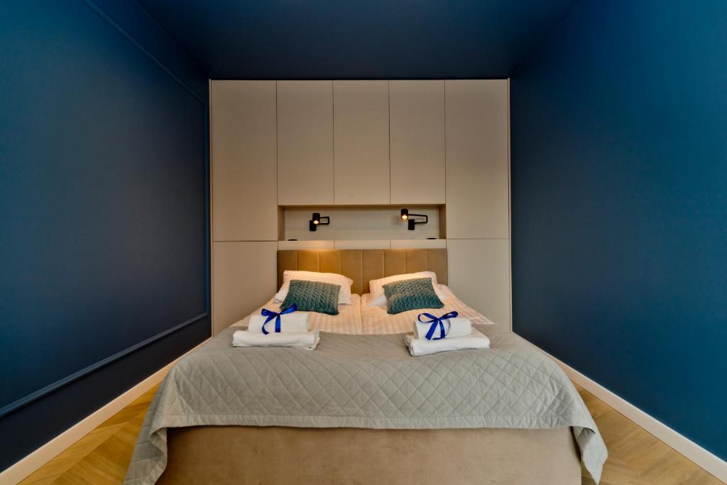 1 dormitorio con 1 cama grande y paredes azules en BlueApart Apartamenty Portowa, en Jastarnia