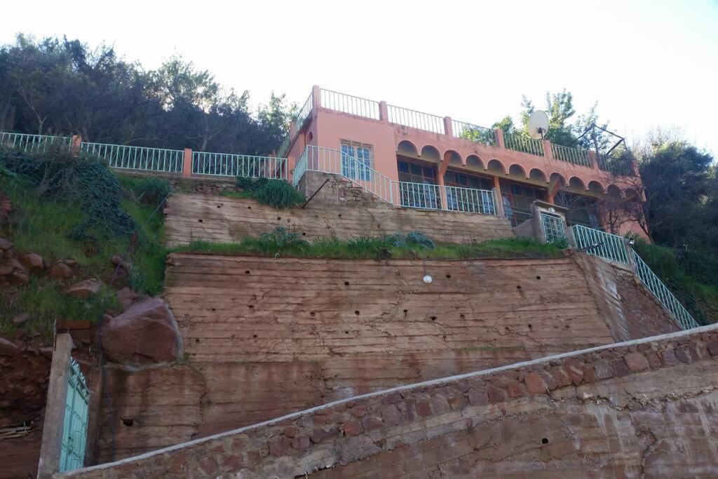 Villa Romancia Ourika Vallee في مراكش: منزل جالس فوق جدار من الطوب