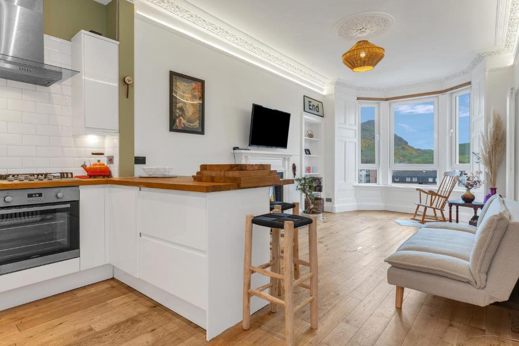 a kitchen with white cabinets and a counter top at spacious flat, close to the city centre with scenic views in Edinburgh