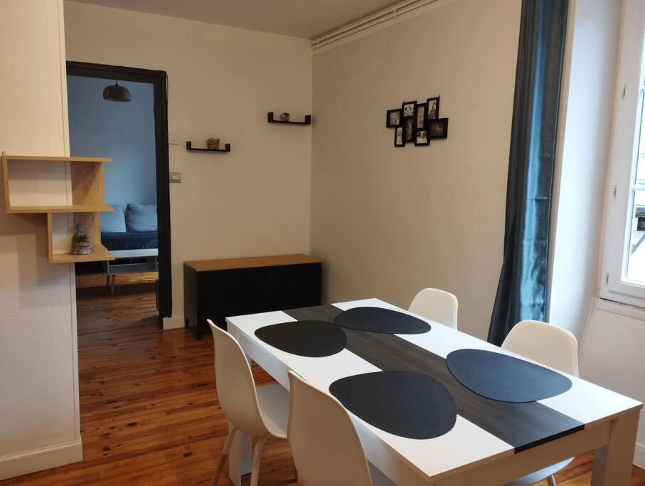 a dining room with a black and white table and chairs at Appartement Foch in Le Puy en Velay