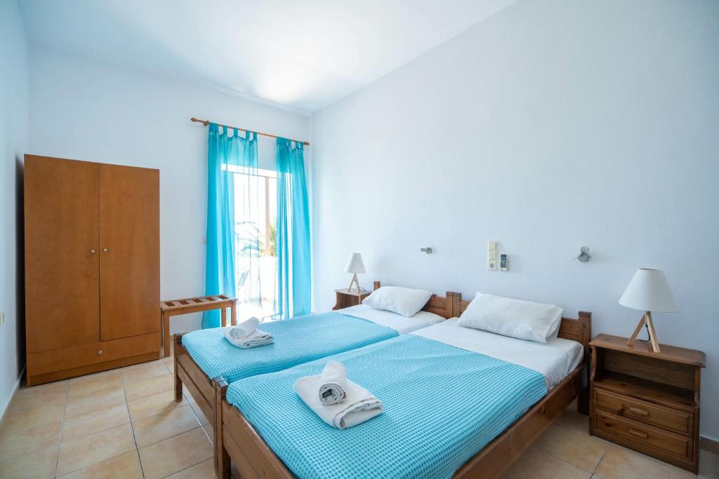 - une chambre avec 2 lits et des serviettes dans l'établissement Milos studios & Beach House, à Frangokastello