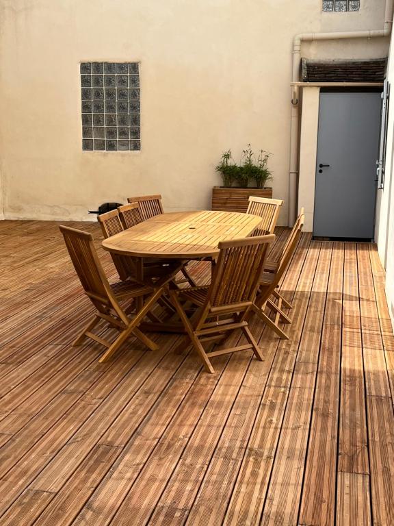 a wooden table and chairs on a wooden floor at Charmant logement rénové dans l’hyper centre in Auxerre