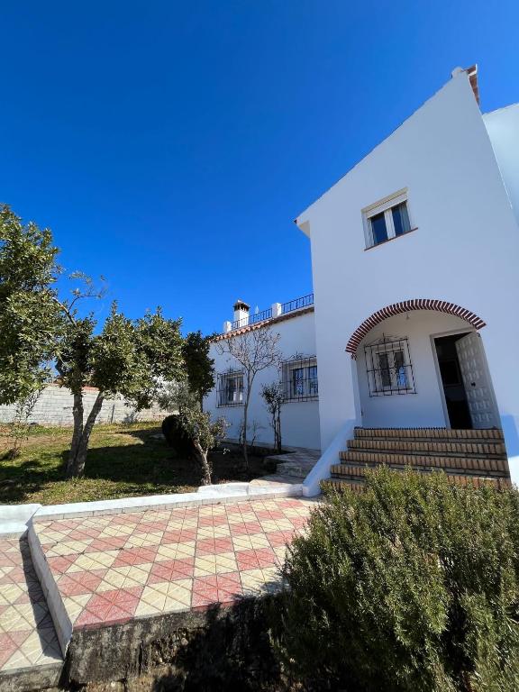 a white building with stairs and a window at Villa Mariaje in Cazalla de la Sierra
