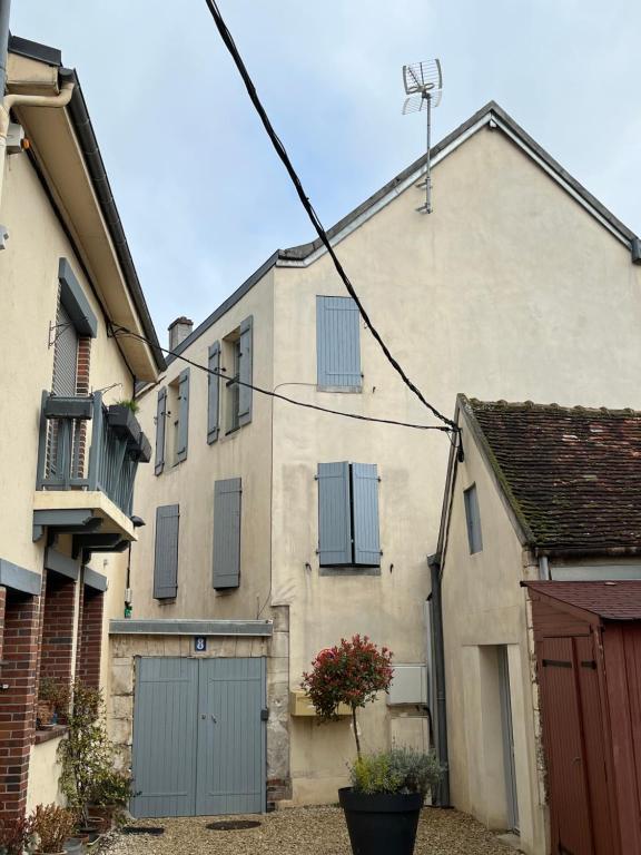 an old house with blue doors and a garage at Charmant logement rénové dans l’hyper centre in Auxerre