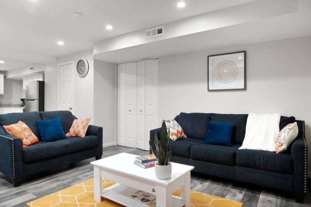 a living room with two blue couches and a table at Elegant 1-BR Apartment in Silver Spring