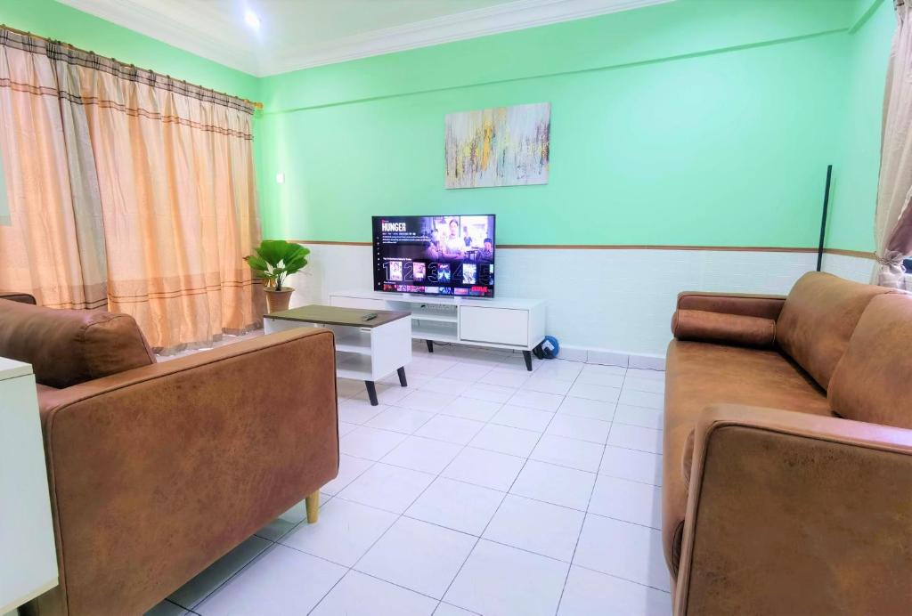 sala de estar con 2 sofás y TV en 3 Rooms 2 parking 10pax PSR Comfy Sofa&Bed near MRT Eateries McD en Seri Kembangan