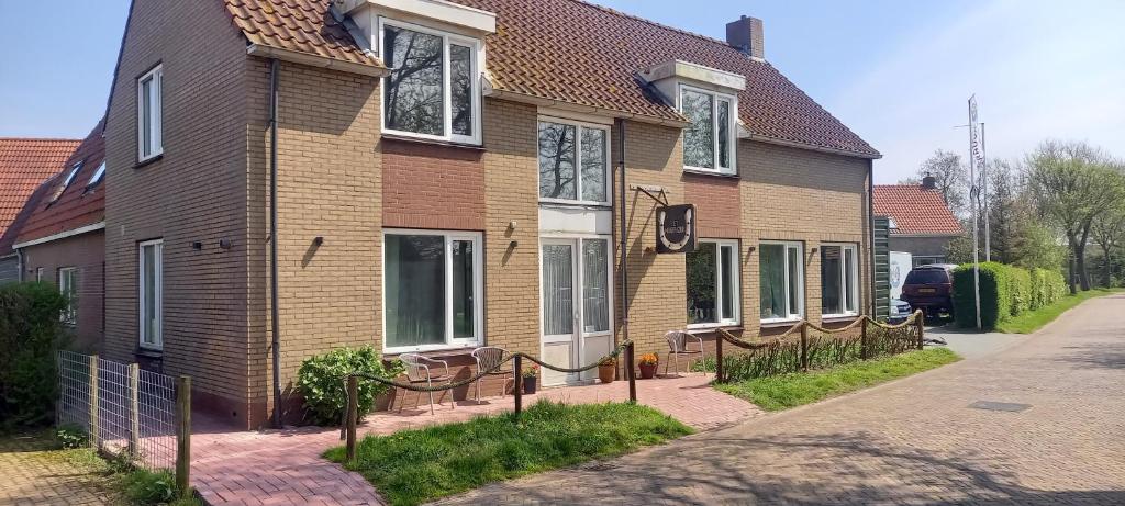 ein Haus mit einem Zaun davor in der Unterkunft Pension Het Hoefijzer in Buren