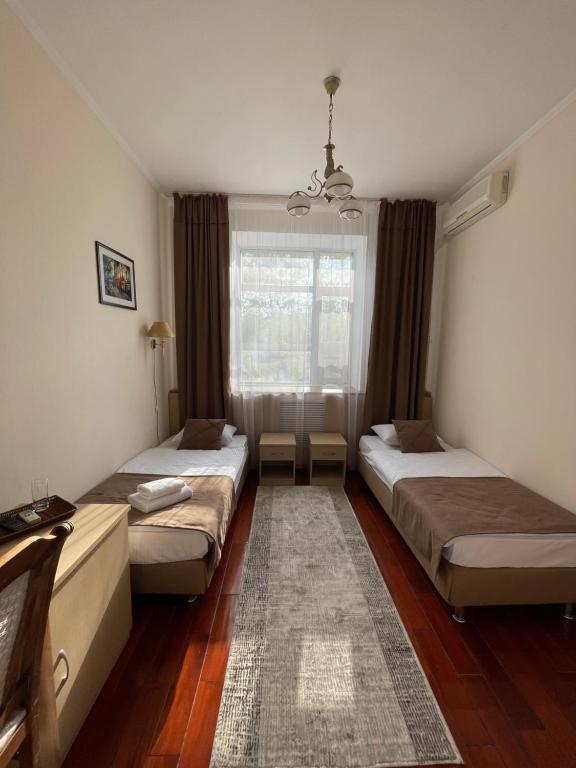 two beds in a room with a window at Belon Land in Astana