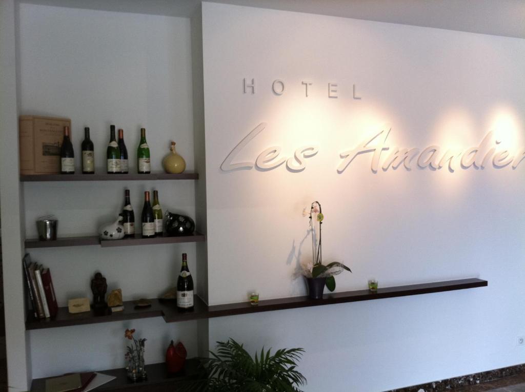 a room with bottles of wine on the wall at Hotel Les Amandiers in Tournon-sur-Rhône