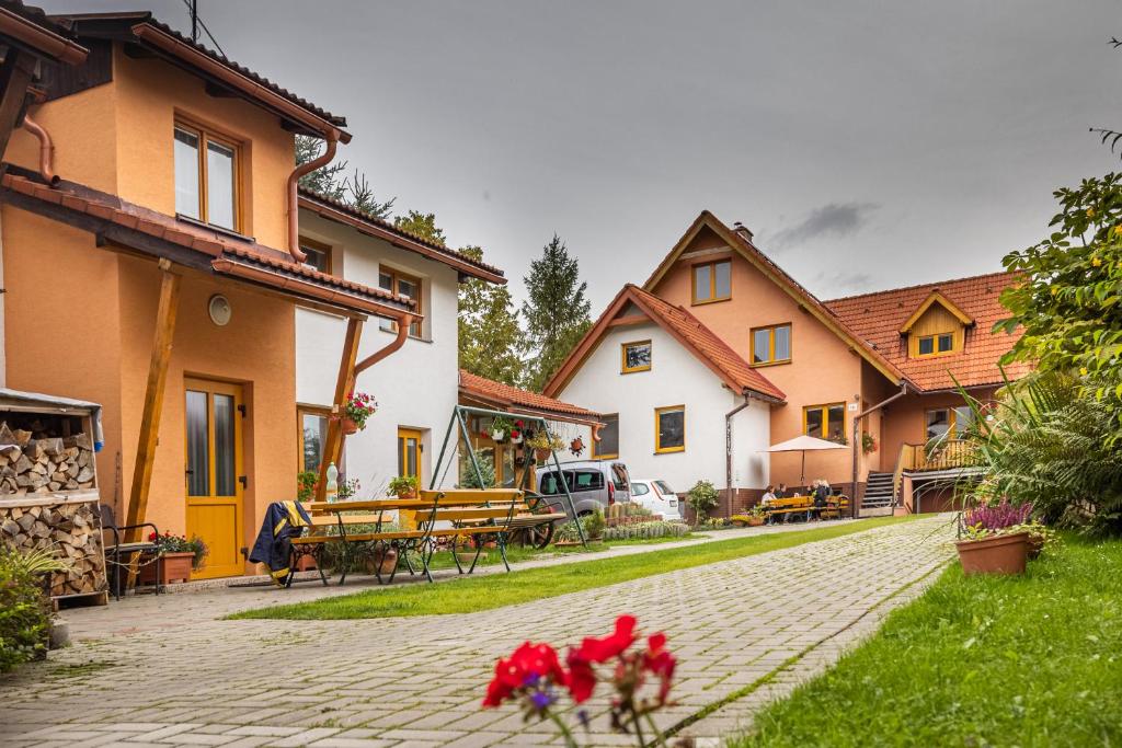 a group of houses with red flowers in the yard at Penzion Jas in Zuberec