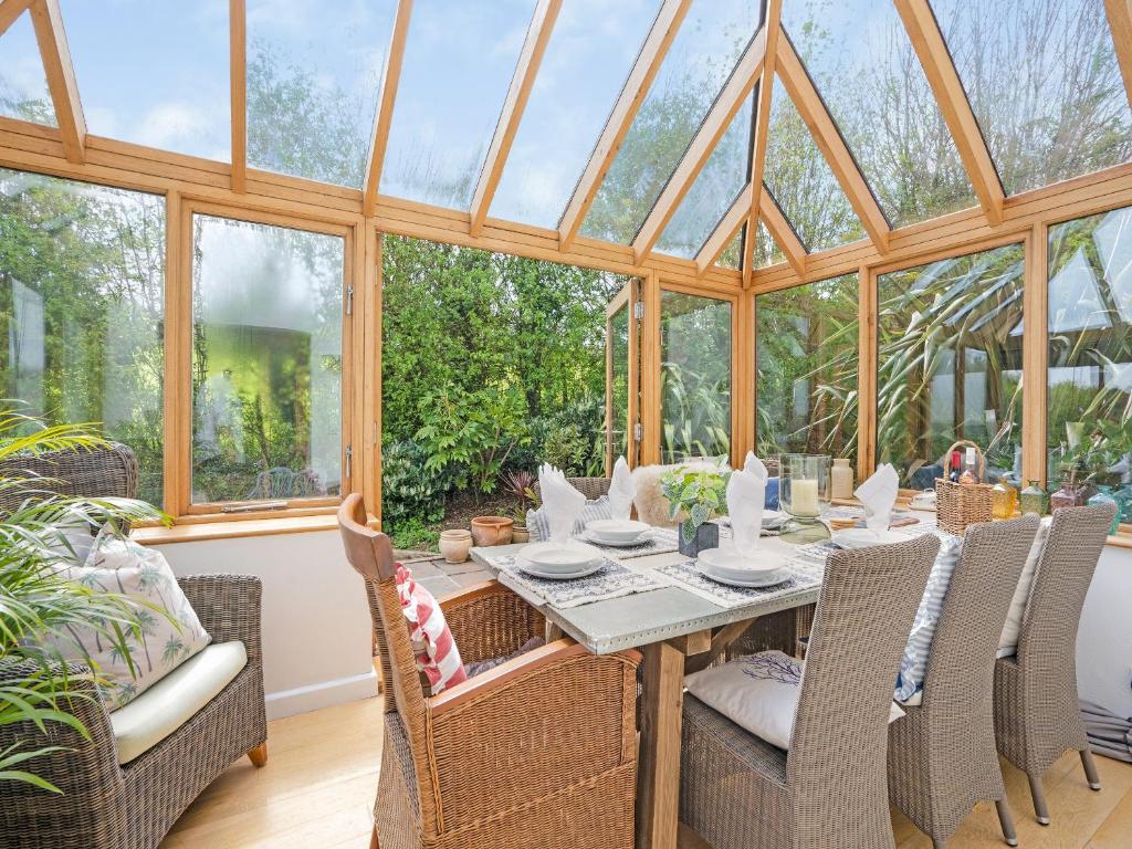 a conservatory with a table and chairs and windows at Toffee Apple in Hemborough Post