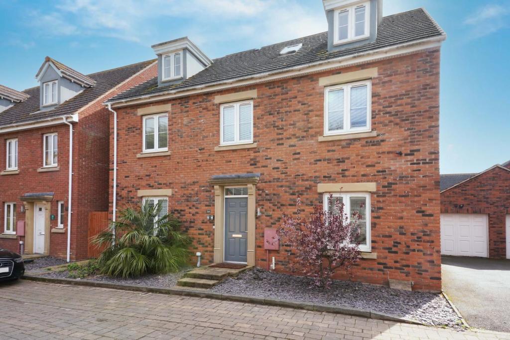 a red brick house with a driveway at Stylish 6 Bedroom 3 Bathroom Detached House with Free Parking, Super-Fast Wifi, Pool Table, Smart TVs with Netflix by Yoko Property in Milton Keynes