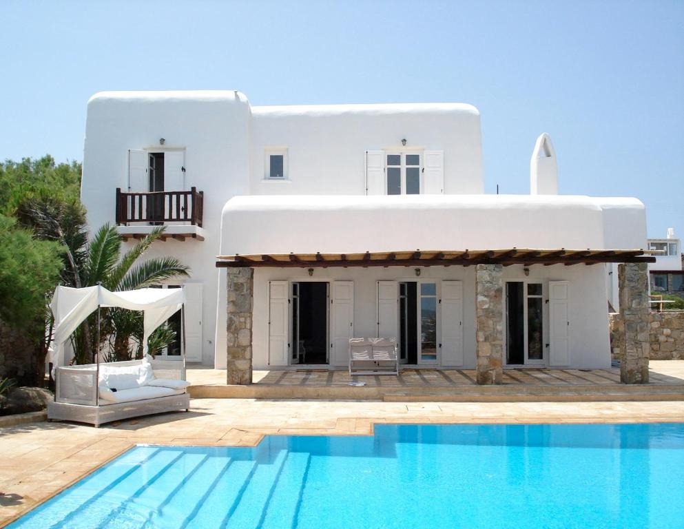 eine Villa mit einem Pool vor einem Haus in der Unterkunft Dreamy Boho 5bed Villa with Pool and Ocean View in Mykonos Stadt