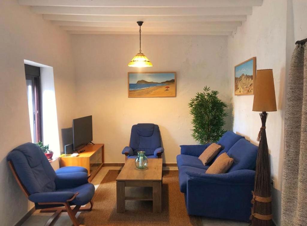 sala de estar con 2 sofás azules y TV en Preciosa vivienda rural en Alpujarra Almeriense en Félix