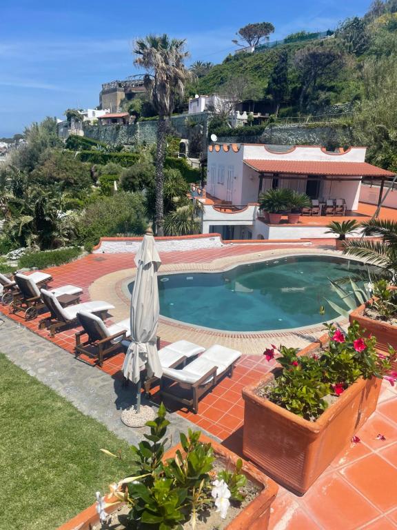 a swimming pool with lounge chairs and a house at Villa la Dimora di Zoè in Ischia