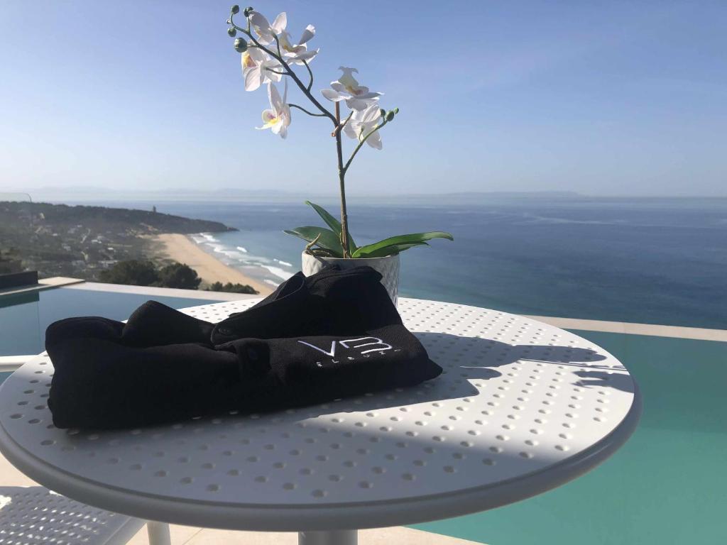 a table with a vase with a flower on it at Villa El Buzo in Zahara de los Atunes