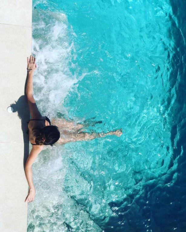 a woman swimming in the water in a pool at Villa El Buzo in Zahara de los Atunes