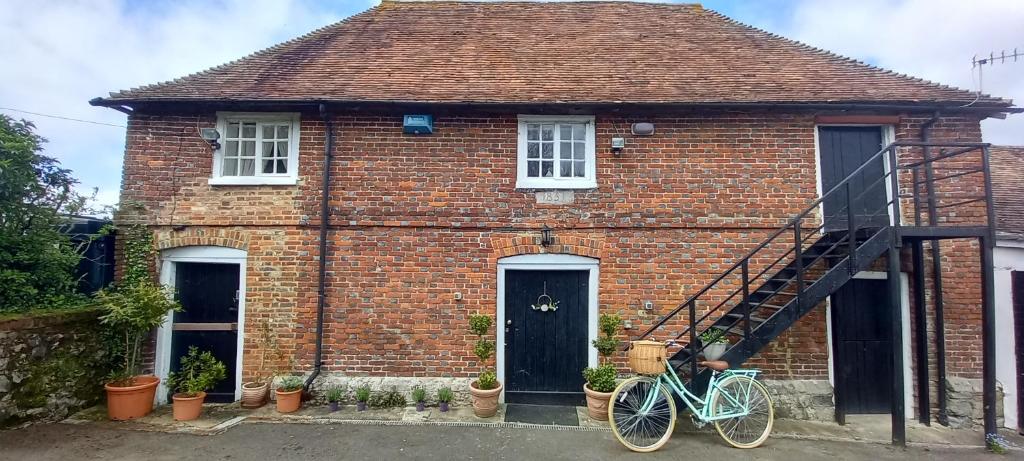 a brick house with a bike parked in front of it at Plumpton Barn in Ashford
