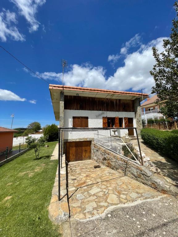 a small white building with a balcony in a yard at Chalet xeitosiño in Astorga