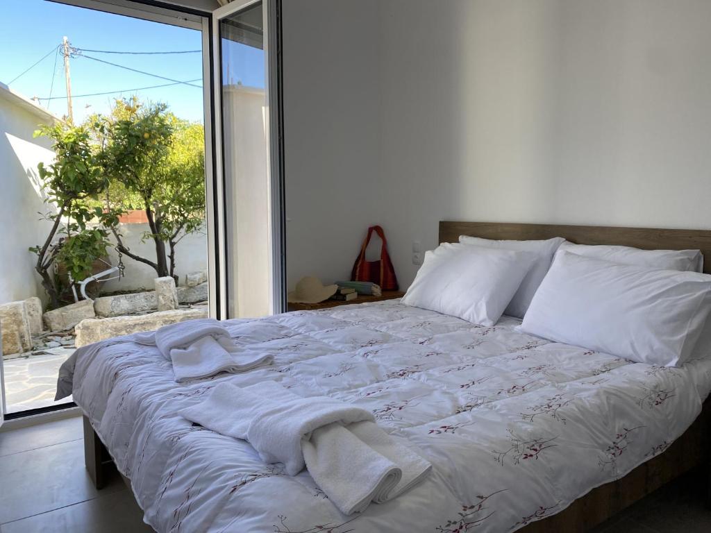 una cama con toallas delante de una ventana en Orphanos House, en Kamilari