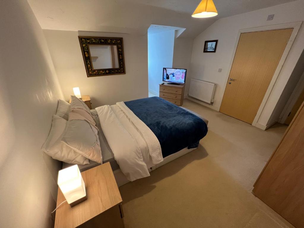 um quarto com uma cama e uma televisão em Priestley Court em Warrington