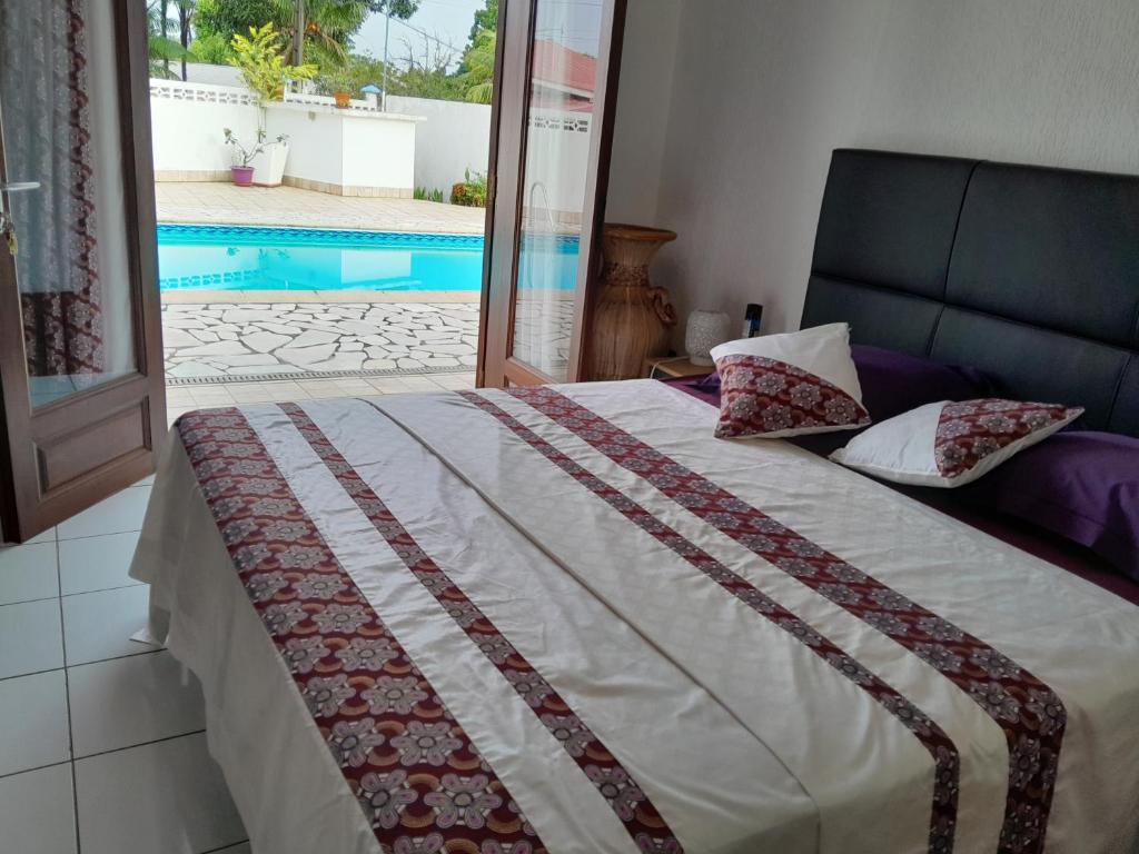 a bedroom with a bed and a swimming pool at Chambre Wassai in Rémiré