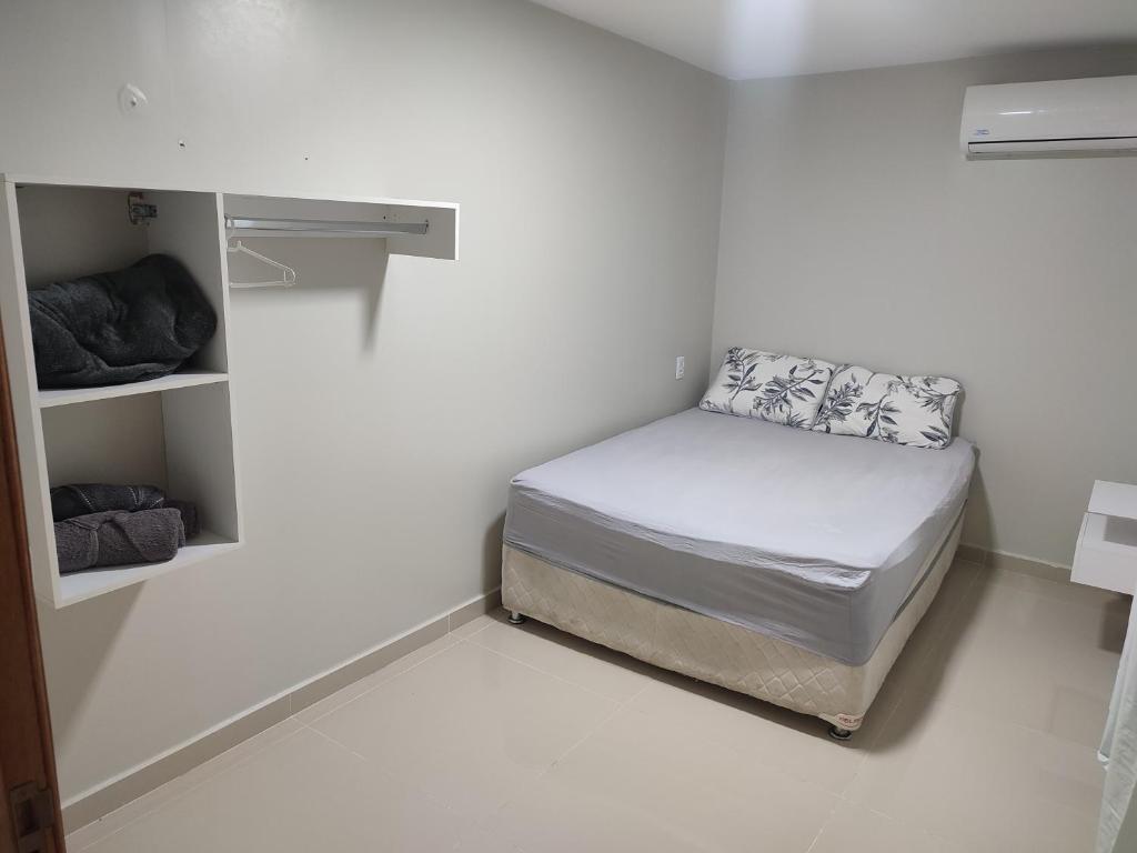 1 dormitorio pequeño con 1 cama en una habitación blanca en JR Casa Contêiners en Boa Vista