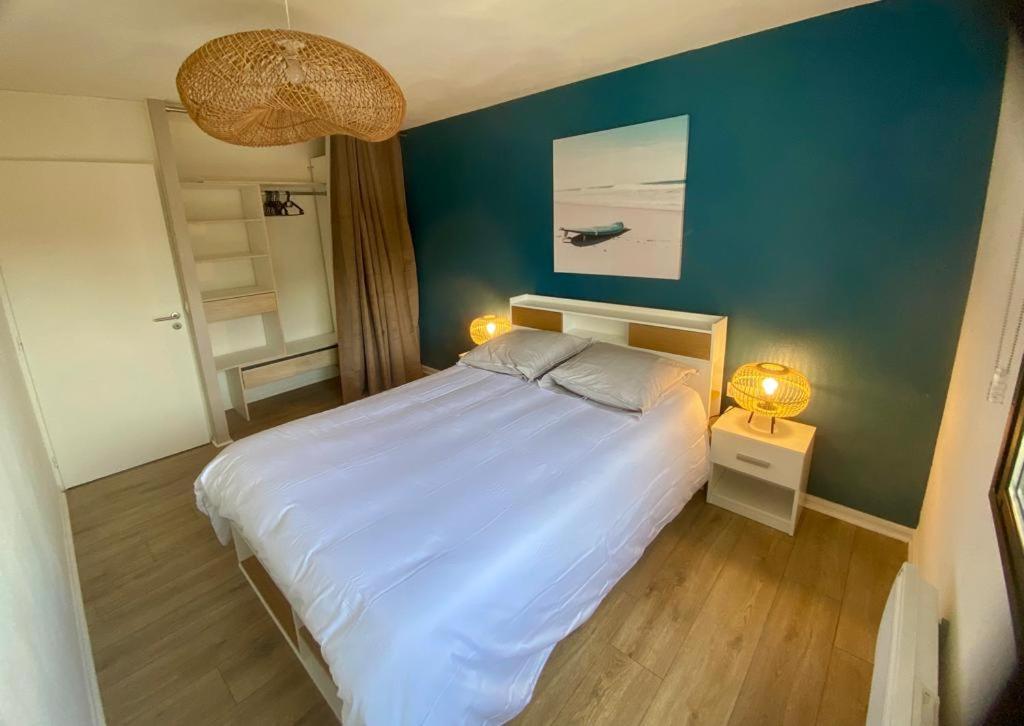 ein Schlafzimmer mit einem großen Bett mit blauer Wand in der Unterkunft Blue ocean in Biscarrosse