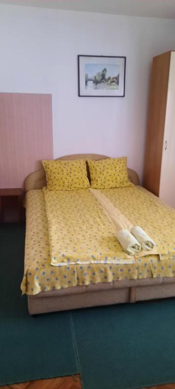 a bedroom with a bed with yellow sheets and yellow pillows at Privatni smeštaj Nanica in Mataruška Banja