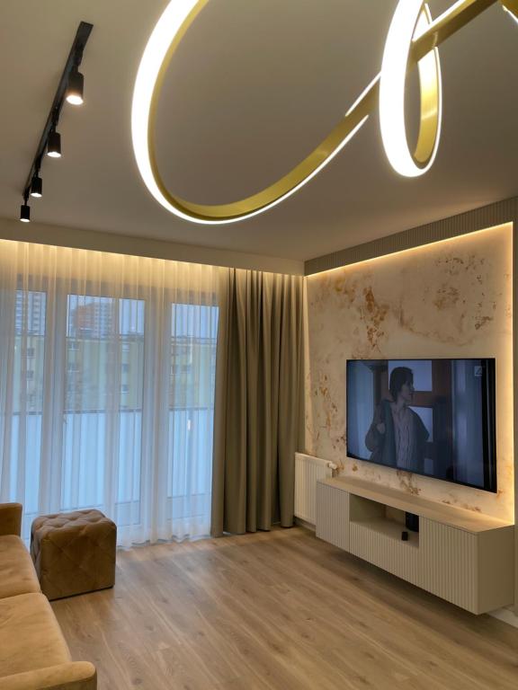 a living room with a large flat screen tv at Moris Park Regana Apartments in Gdańsk