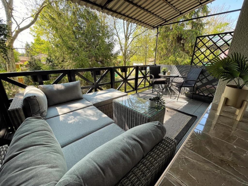 een patio met een bank en een tafel op een terras bij Balaton Breeze Apartman in Fonyód