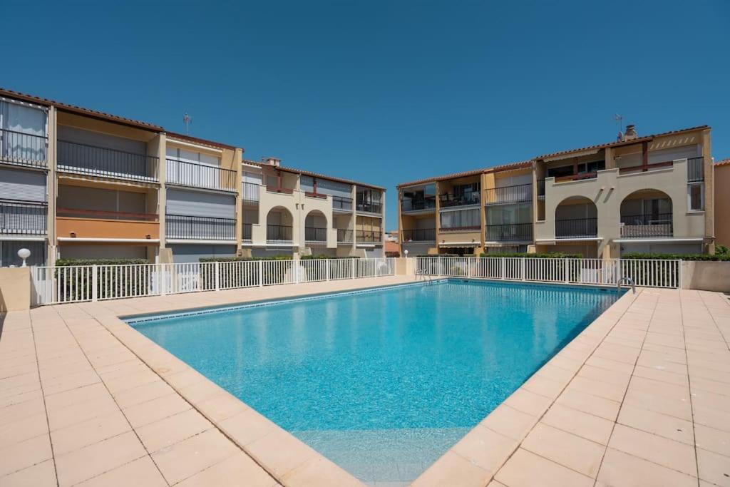 een zwembad voor sommige appartementsgebouwen bij Appartement 5 personnes vue mer in Cap d'Agde