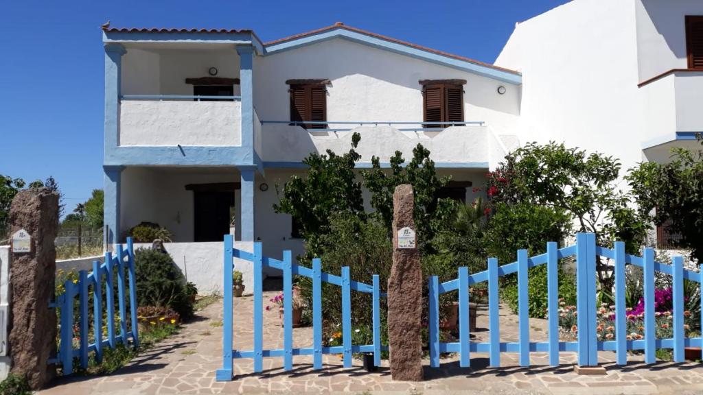 una cerca azul frente a una casa blanca en Appartamento vista mare, en Calasetta