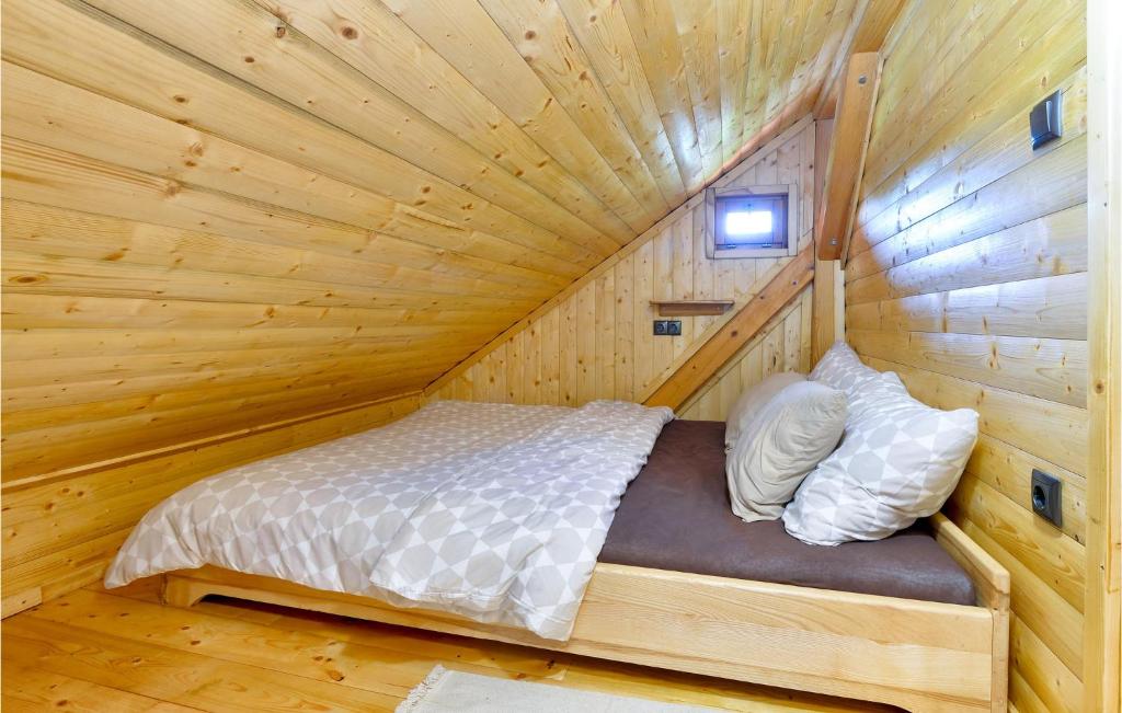 a bed in a log cabin with a wooden ceiling at Beautiful Home In Kraljev Vrh With Wifi in Kraljev Vrh