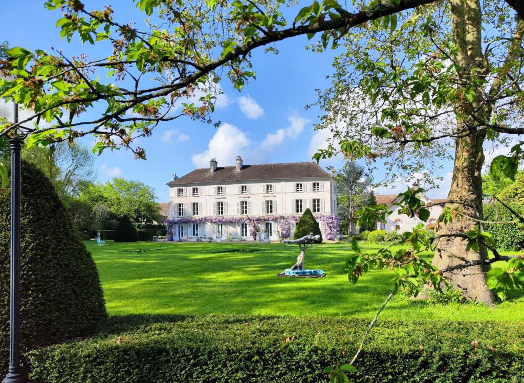 una gran casa blanca en un césped verde en CHATEAU DE BRINVILLE, en Saint-Sauveur-sur-École