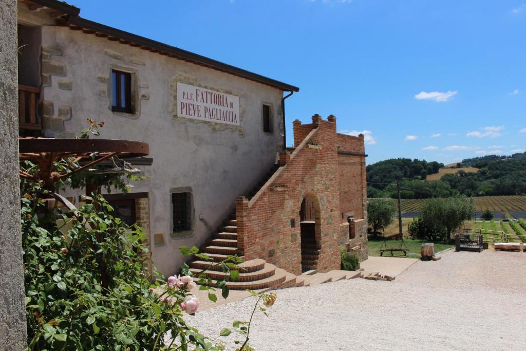 un edificio de ladrillo con una escalera que conduce a una puerta en Fattoria di Pieve Pagliaccia - Cantina Brugnoni, en Perugia