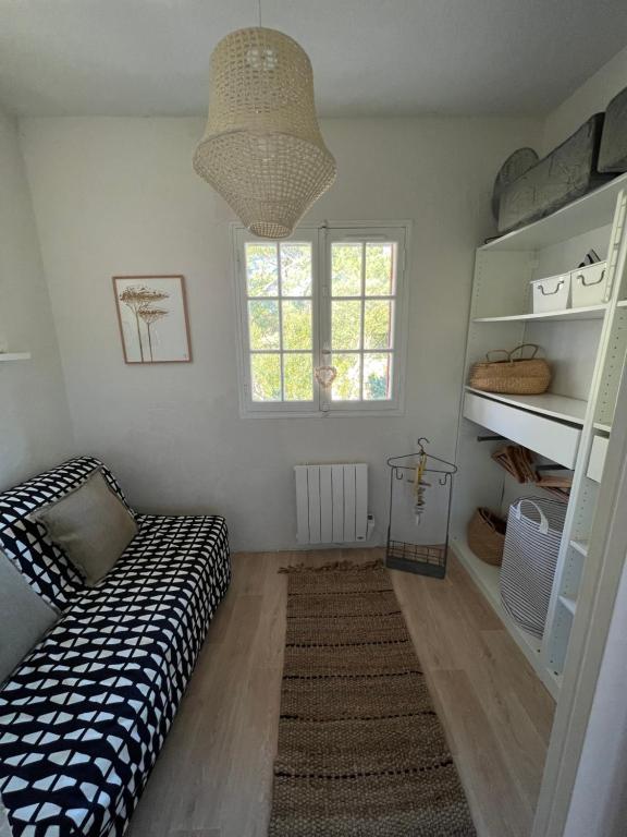 アルカションにあるLe Ptit Moulleauのベッド、窓、棚が備わる客室です。