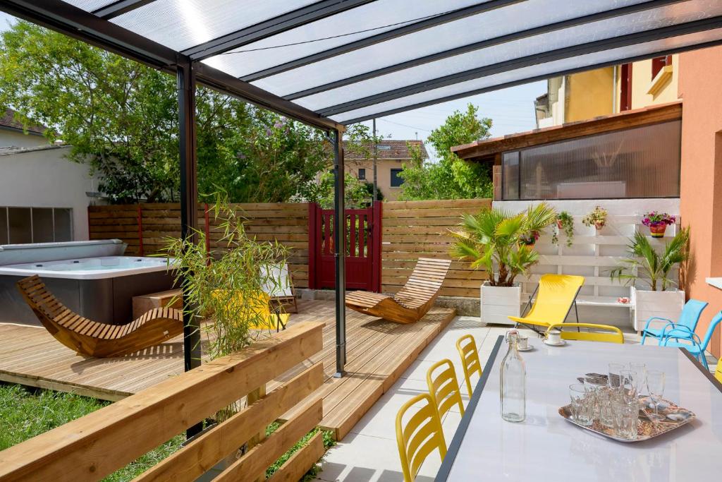 un patio al aire libre con mesa y sillas en Chez Odette - SPA, Barbecue, Parking, en Albi